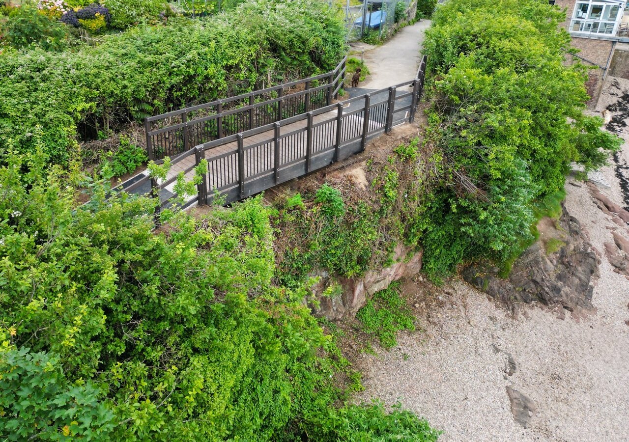 New FRP footbridge at Portishead Yacht and Boat Club seen from above, on the coastal path above Sugar Loaf Beach