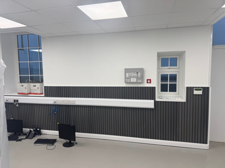 Refitted main office with replacement windows, slatted wall cladding and fire alarm panel