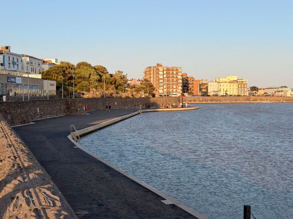 Resurfaced walkway and new access steps curving around Marine Lake, Weston-super-Mare, with the seafront behind